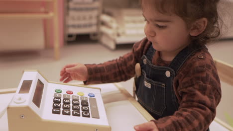 Boy-Playing-Cash-Register-Toy-While-Sitting-Inside-Ikea-Store