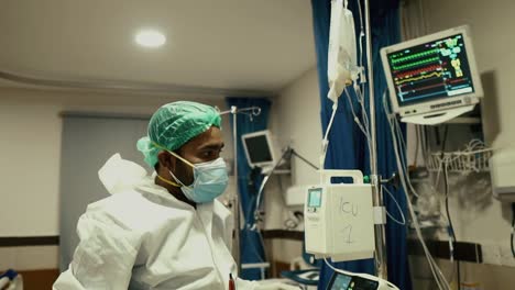 Médico-Revisando-El-Goteo-Intravenoso-En-La-Sala-Del-Hospital-En-Karachi