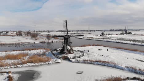 Dutch-windmills-in-snowy-winter-landscape,-aerial-view