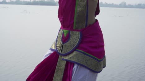 Una-Bailarina-De-Bharatnatyam-Que-Muestra-Una-Pose-Clásica-De-Bharatnatyam-En-La-Naturaleza-Del-Lago-Vadatalav,-Pavagadh