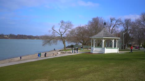 Gazebo-at-Niagara-On-The-Lake-near-beach-and-lake-view-on-beautiful-bright-day-with-bright-blue-sky-with-people-enjoying-life-and-walking-around-with-grass-and-sand