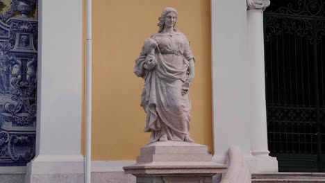 Statue-Einer-Frau-Mit-Einer-Büste-Und-Einem-Gebäude-Im-Hintergrund