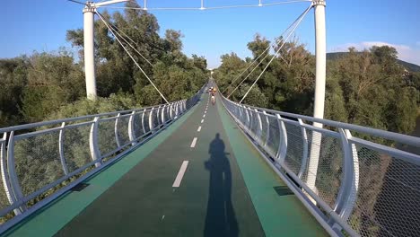 First-person-GoPro-point-of-view-cycling-over-bridge-in-nature,-Slovakia