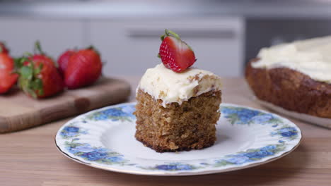Carrot-Cake-with-Icing-and-Strawberry-on-a-Porcelain-Plate