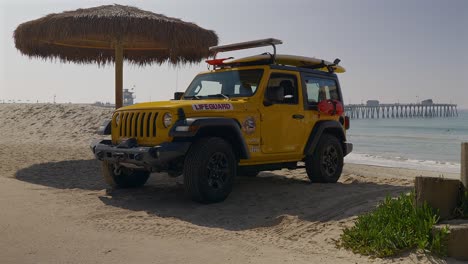 Yellow-lifeguard-Jeep-sitting-next-to-a-thatch-umbrella-in-San-Clemente-California