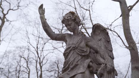 Muy-Antigua-Y-Antigua-Estatua-De-ángel-Cubierta-De-Musgo-Con-Vistas-Al-Antiguo-Cementerio-En-Uzupis