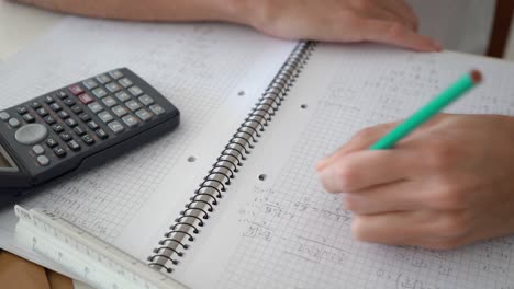 Hand-Löst-Algebraisches-Problem-Auf-Einem-Mathe-Notizbuch-Mit-Wissenschaftlichem-Taschenrechner-An-Der-Seite