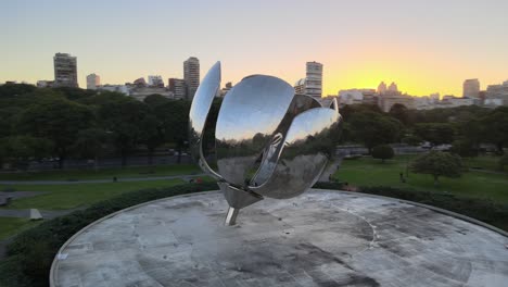Orbit-of-Floralis-Generica-steel-sculpture-in-Naciones-Unidas-square-with-Recoleta-buildings-in-background-at-sunset