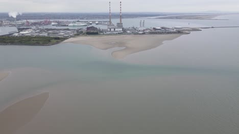 Sandymount-Strand-Beach-With-View-On-The-Poolbeg-Of-Old-And-New-Power-Plant-In-Dublin,-Ireland---aerial-drone-shot