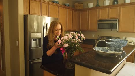 Woman-walks-into-kitchen-and-finds-pink-rose-flowers-on-the-counter