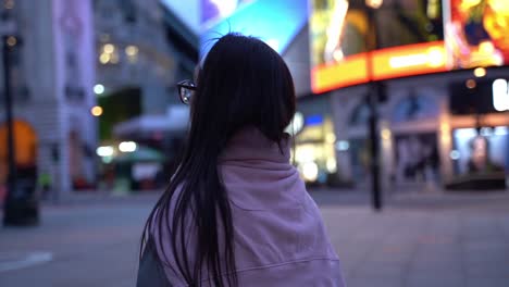 Young-woman-seen-from-behind-in-Picadilly-Circus,-London,-close-up-slowmo