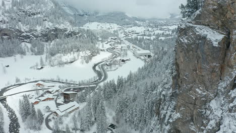 Aerial-reveal-of-beautiful-small-town-surrounded-by-snow-covered-wilderness