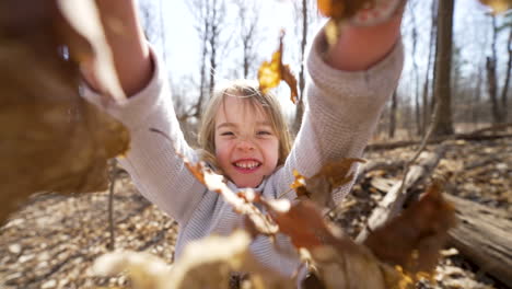 Glückliches-Kleines-Mädchen,-Das-In-Einem-Herbstlichen-Wald-Blätter-In-Die-Luft-Wirft