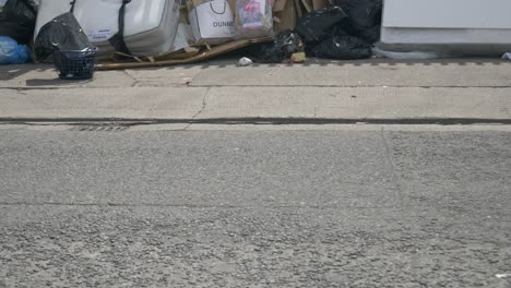 Müllhaufen,-Der-Auf-Der-Leeren-Straße-Mit-Schildern-Im-Zaun-In-Dublin,-Irland,-Abgeladen-Wurde