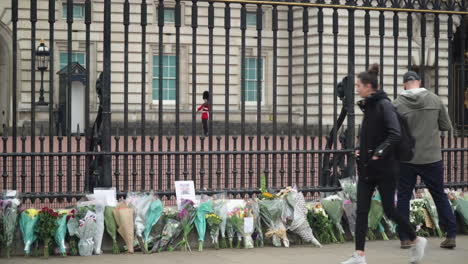 Flowers-laid-in-tribute-of-Price-Philip-while-a-guard-patrols-at-Buckingham-Palace