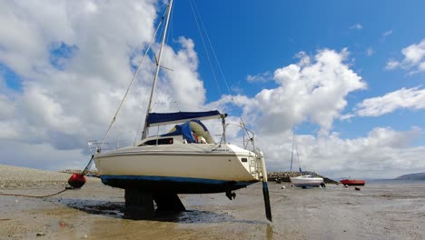 Fast-changing-weather-above-single-moored-fishing-boat-on-low-tide-coast-sunny-conditions
