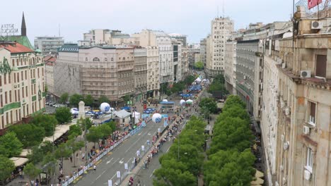 People-running-Belgrade-Marathon-in-Serbia,-aerial-view-of-runners-in-city