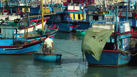 Two-fisherman-navigate-coracle-boat-between-fishing-vessels-in-Vinh-Hy-harbour