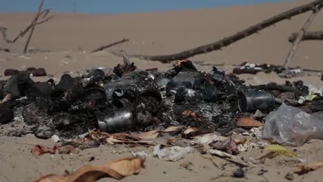 Burned-household-garbage-in-sand-dunes-landscape