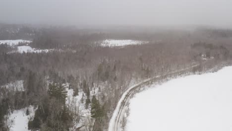 Aerial-flying-high-above-Winter-forestry-view-with-thick-snowfall