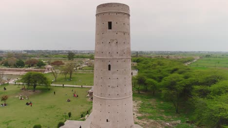 Tracking-Aerial-Shot-Of-Hiran-Minar-Tower,-Tourists-Visit-Famous-Landmark-In-Pakistan