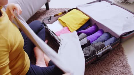 Detail-of-female-hands-arranging-clothes-in-takeout-suitcase