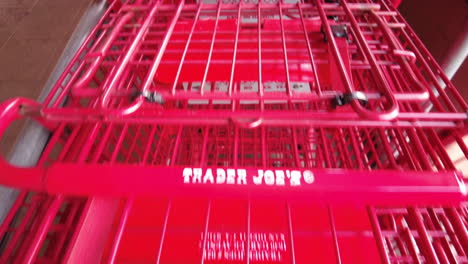Sliding-Shot-Over-Red-Shopping-Carts-In-A-Row-Inside-Trader-Joe's-Grocery-Store-In-Point-Loma,-San-Diego