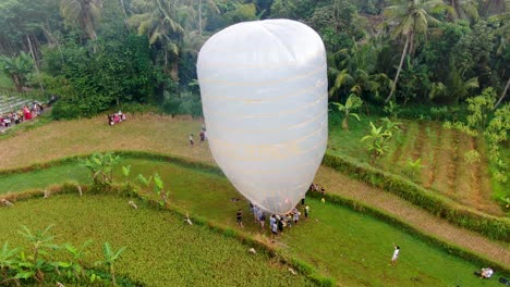 Indonesian-rural-community-inflating-hot-air-balloon-ready-to-launch-at-festival