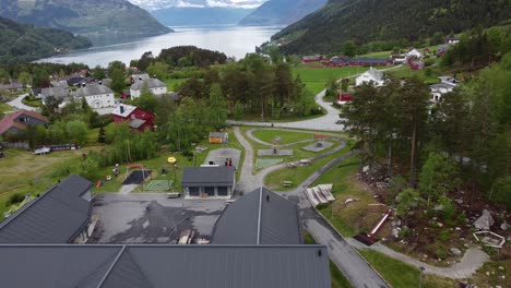 Public-daycare-kindergarten-with-playground-in-the-village-of-Kinsarvik-Ullensvang-Hardanger---Norway-aerial-with-people-on-kindergarten