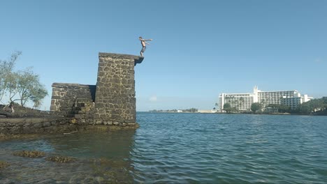 Young-Man-does-a-backflip-from-a-stone-made-dive-platform-into-the-ocean
