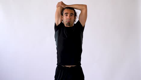 Hispanic-Man-with-Long-Hair-and-Goatee-Performing-Tricep-Stretch-Against-White-Studio-Backdrop