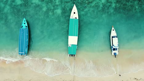 Aerial-top-down-view-of-three-long-boats-parked-on-the-seashore