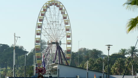 Ferris-Wheel-On-A-City-Coastline-During-A-Sunny-Morning