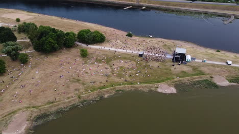 Music-festival-in-two-river-conjunction-with-crowd-of-people,-aerial-drone-view