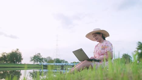 Adult-woman-sitting-on-lawn-working-with-computer