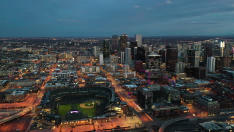 Cinematic-Aerial-View-of-Downtown-Denver-at-Night,-Coors-Field-Baseball-Stadium-and-Central-Financial-District,-Colorado-USA