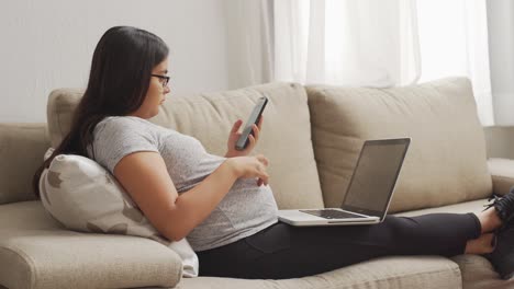 Eine-Junge-Schwangere-Latinx-Frau,-Die-Am-Laptop-Arbeitet
