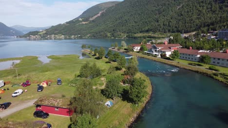 Fondo-Del-Río-Loen-Que-Termina-En-El-Innvikfjord---Antena-En-Movimiento-Hacia-Adelante-Del-Hermoso-Río-Con-Agua-De-Glaciar-Verde---Camping-De-La-Bahía-De-Loen-A-La-Izquierda-Y-Hotel-De-Loenfjord-A-La-Derecha---Noruega