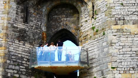Caernarfon-castle-tourist-taking-selfie-on-observation-viewing-platform-overlooking-landmark-town
