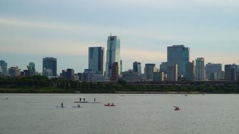 Modern-Cityscape-With-Tourists-Kayaking-And-Paddle-Boarding-In-Han-River,-Seoul,-Gangnam-District,-South-Korea