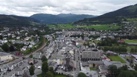 Voss-city-center---Aerial-view-showing-main-street-with-buildings-and-shops---Railway-to-the-left-and-mountains-in-distant---Norway