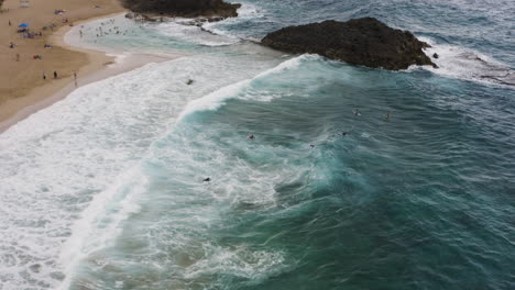 Menschen-Schwimmen-Und-Surfen-Am-Strand-La-Poza-Del-Obispo-Mit-Großen-Wellen-In-Arecibo,-Puerto-Rico