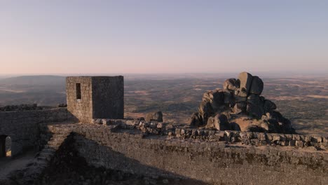 Drohne-Fliegt-über-Den-Aussichtspunkt-Der-Monsanto-Ruinen-Bei-Sonnenaufgang,-Portugal
