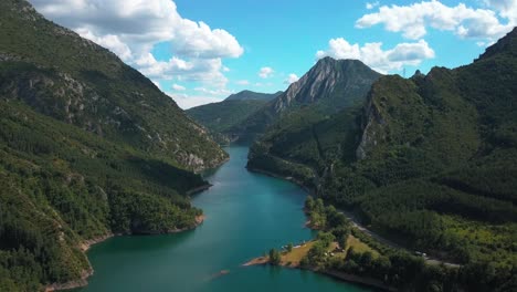 Aerial-horizontal-4K-footage-of-a-lake-in-a-green-natural-environment-with-mountains-in-the-Spanish-Pyrenees