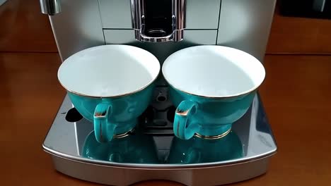 Two-beautiful-chinese-porcelain-tea-pots-are-positioned-on-a-superautomatic-coffee-machine