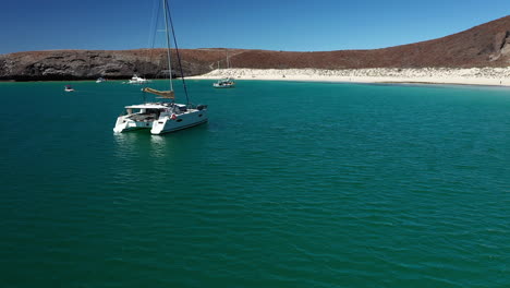 Boats-Adrift-Off-The-White-Sand-Shoreline-Of-Playa-Balandra-In-La-Paz,-Mexico