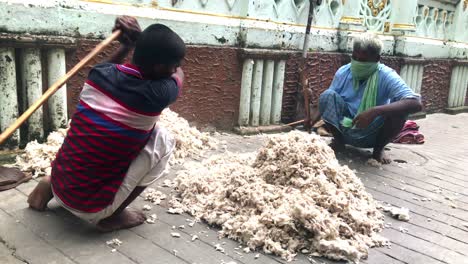 Indian-men-sewing-pillows-at-the-street-in-Kolkata,-India