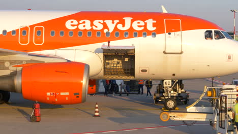 Offener-Gepäckraum-Und-Frachtbereich-Des-Easyjet-Airbus-Am-Flughafen-Bergamo-In-Italien-Mit-Bodenpersonal-Im-Vordergrund
