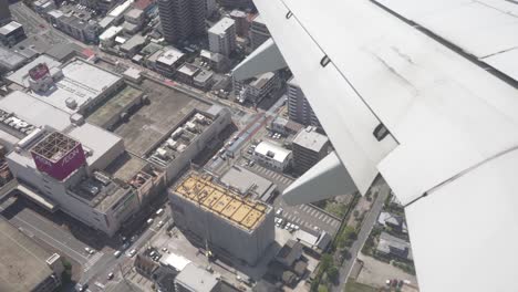 POV-Of-A-Passenger-Looking-At-Buildings-Through-Window-Of-Airplane-Flying-In-City-Of-Tokyo-In-Japan