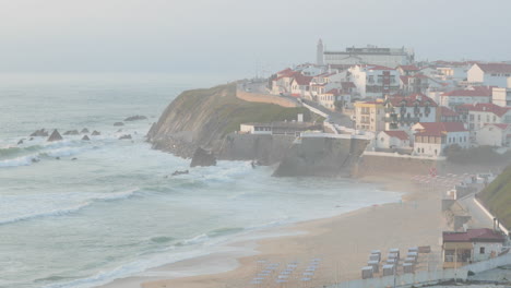 Raue-Wellen-Am-Strand-Von-Sao-Pedro-De-Moel-Mit-Blick-Auf-Das-Dorf-An-Einem-Nebligen-Morgen-In-Leiria,-Portugal